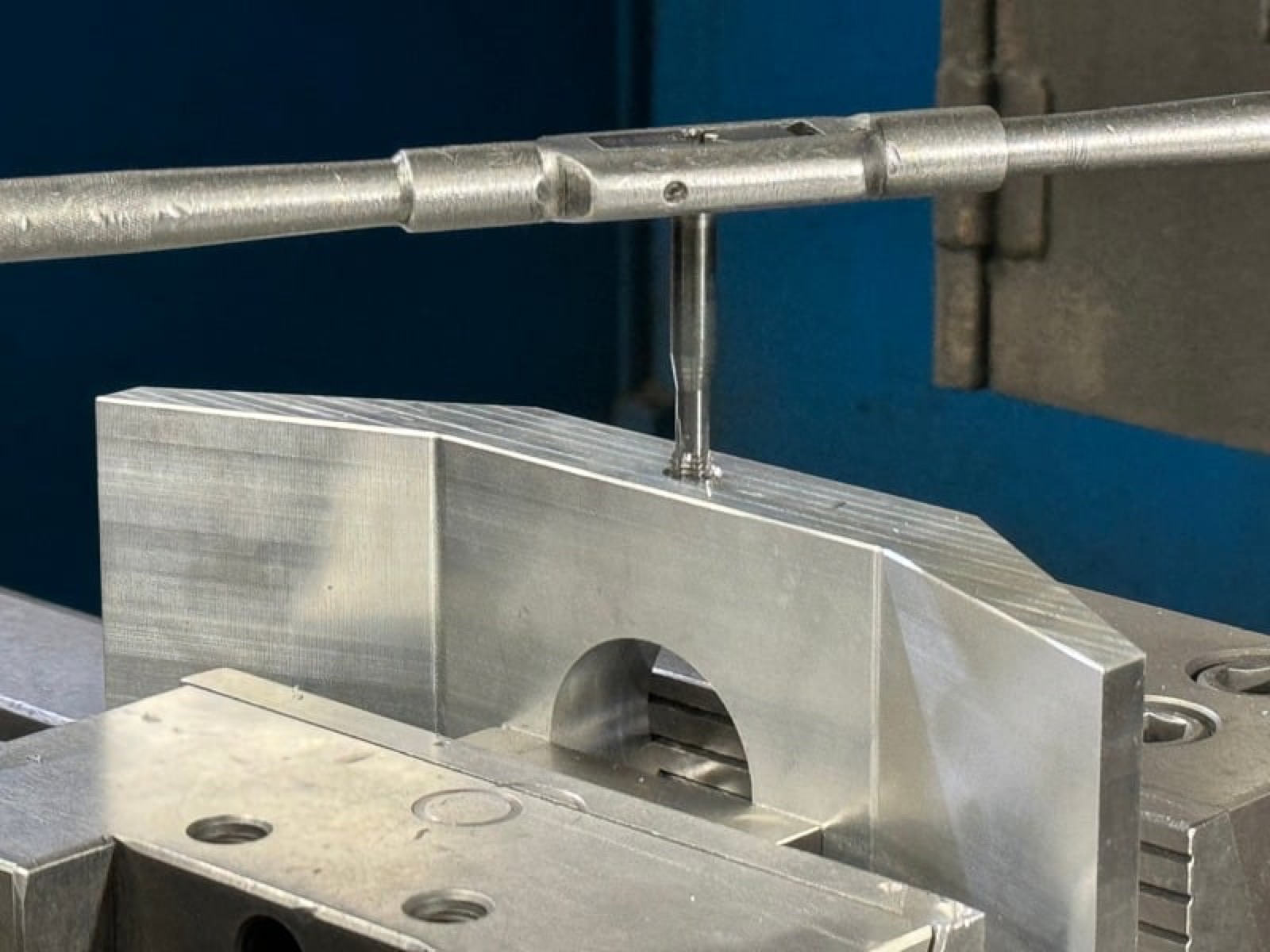 Aluminum component held in a vise during machining